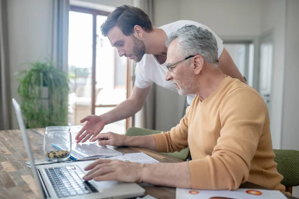 İki adam bir projede birlikte çalışıyor ve ilgileniyorlar.