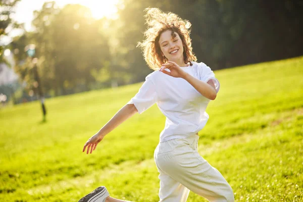 Ruda długowłosa dziewczyna spędza czas w parku czując się szczęśliwa — Zdjęcie stockowe