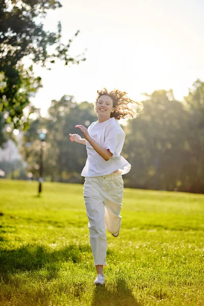 Una chica pelirroja de pelo largo que pasa tiempo en un parque sintiéndose feliz —  Fotos de Stock