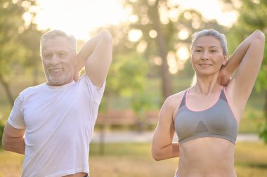 Orta yaşlı bir çift sabah antrenmanından önce geriniyor.