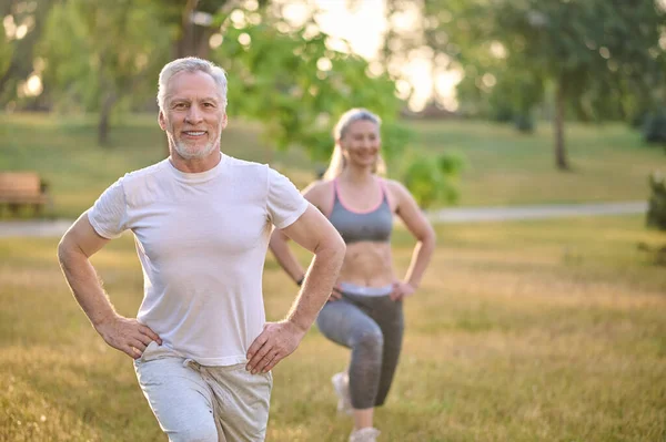 Ett medelålders par som tränar i parken — Stockfoto
