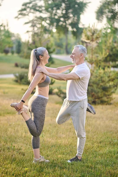 Ett medelålders par som sträcker sig före morgonträningen — Stockfoto