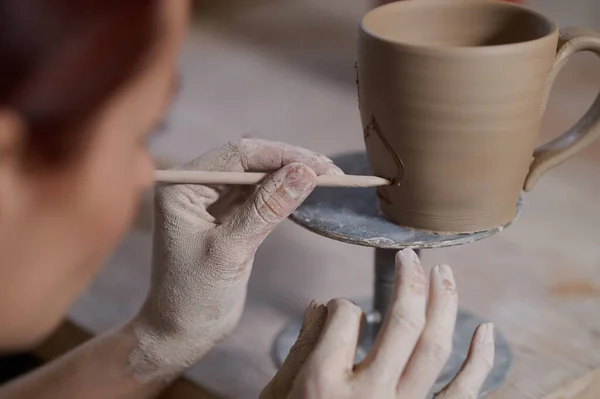Молода жінка малює чашку і виглядає залученою — стокове фото