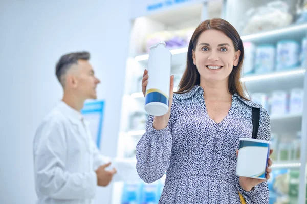 Glückliche Frau mit eingekauften Medikamenten und Apotheker — Stockfoto