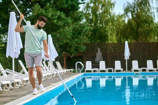 Una persona de servicio que limpia la piscina y se ve ocupada —  Fotos de Stock