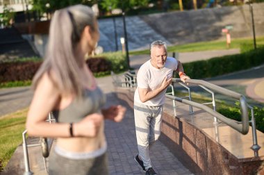 Yetişkin bir çift sabah parkta koşuyor.