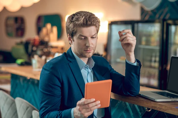 Hombre buscando interesado en tabletas en la cafetería —  Fotos de Stock