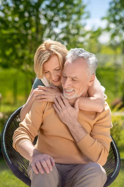 Feliz marido disfrutando de sus cariñosas esposas abrazos — Foto de Stock