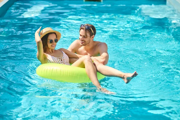 Una joven pareja feliz nadando en una piscina — Foto de Stock