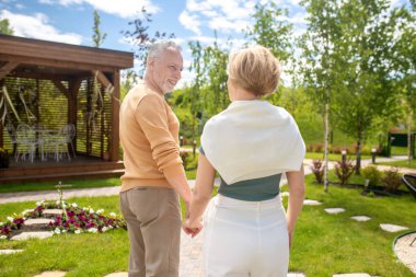 Yürürken karısına bakan sevgi dolu bir adam.