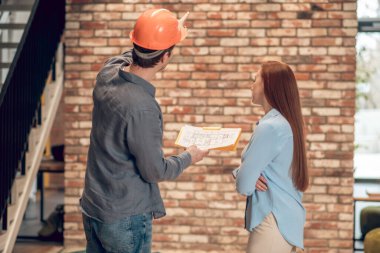 İnşaat planı ve kadın olan bir adamın arka görüntüsü