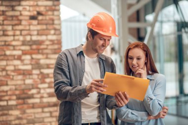 Gülümseyen adam ve kadın çizime bakıyor.