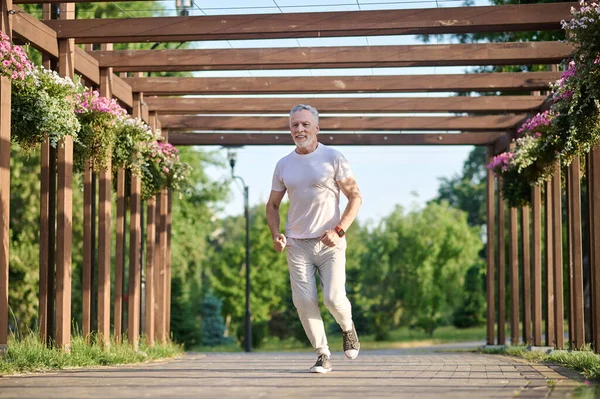 Чоловік у спортивному одязі біжить у парку — стокове фото