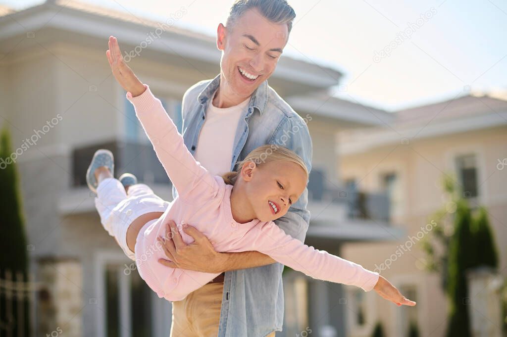 Dad and little daughter playing plane