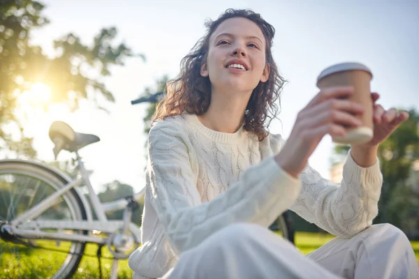 Młoda dziewczyna z filiżanką kawy wyglądająca na napaloną — Zdjęcie stockowe