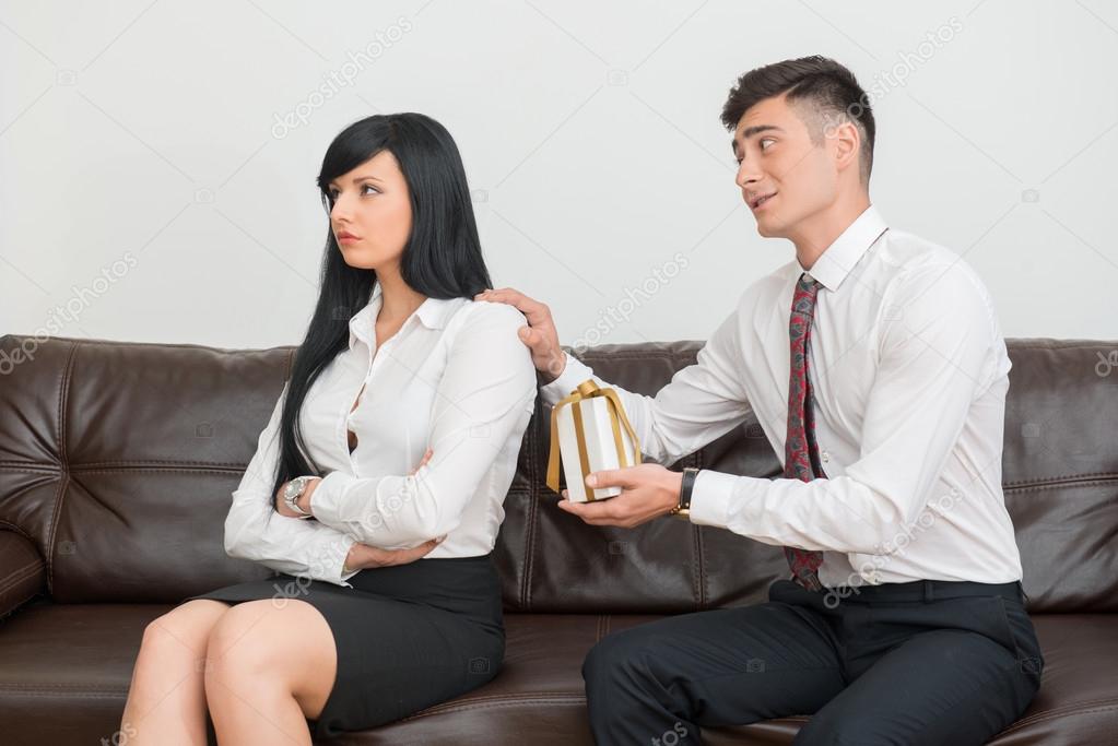 Business couple sitting on sofa in office