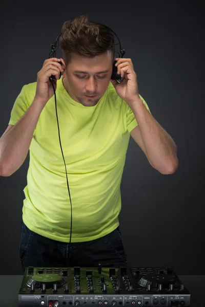 Dj en el trabajo aislado sobre fondo gris oscuro — Foto de Stock