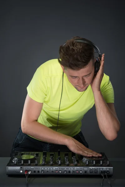 Dj en el trabajo aislado sobre fondo gris oscuro — Foto de Stock