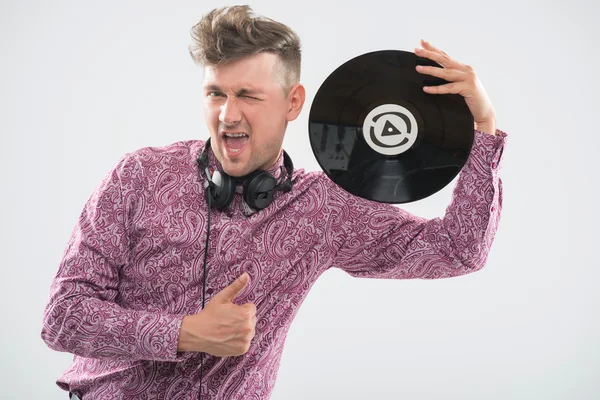 DJ poseren met vinyl record en duim omhoog — Stockfoto