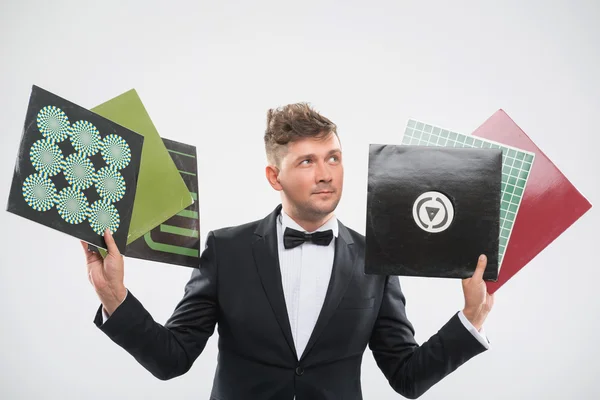 DJ in tuxedo showing his vinyl records standing by turntable — Stock Photo, Image