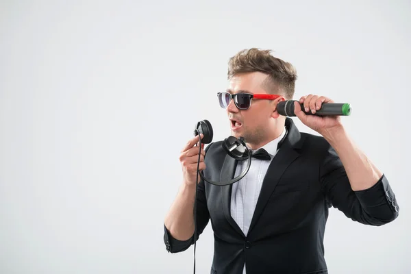 DJ in tuxedo having fun talking into headphones and listening mi — Stock Photo, Image