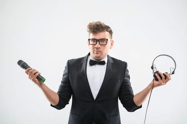 DJ в смокінгу тримає мікрофон та навушники — стокове фото