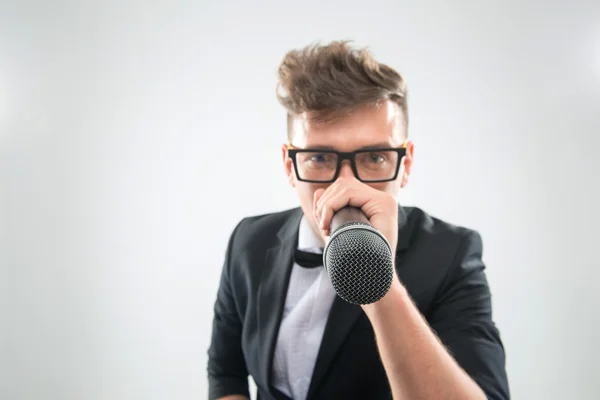 DJ em smoking segurando microfone e fones de ouvido — Fotografia de Stock