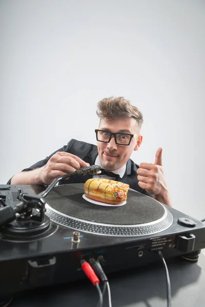 DJ isst Donut am Arbeitsplatz Plattenspieler — Stockfoto