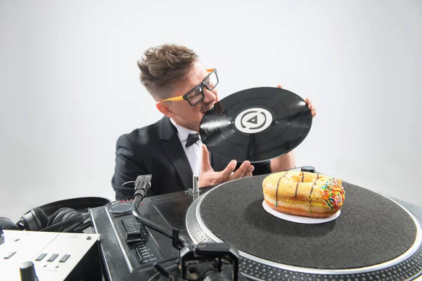 Dj eating donut on working place turntable — Stock Photo, Image