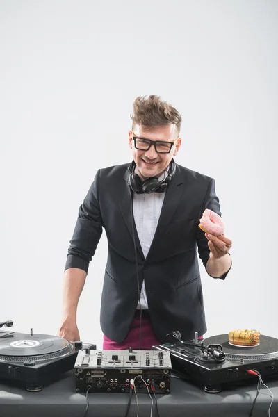 Dj eating donut on working place turntable — Stock Photo, Image