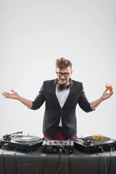 Dj eating donut on working place turntable — Stock Photo, Image