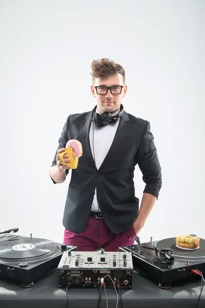 DJ τρώει ντόνατ στον περιστρεφόμενο δίσκο θέση εργασίας — Φωτογραφία Αρχείου