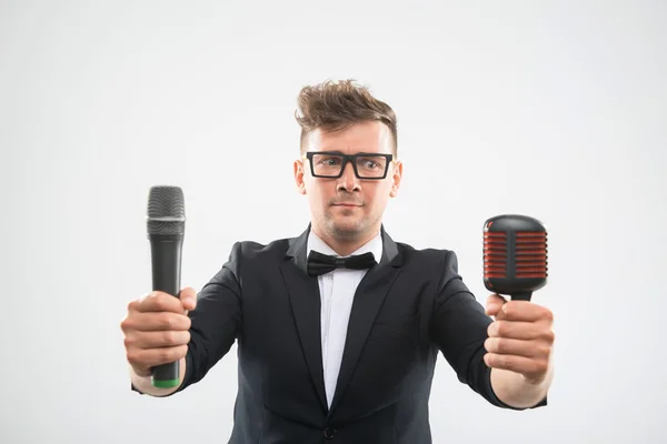 DJ in tuxedo posing with two microphones Stock Image