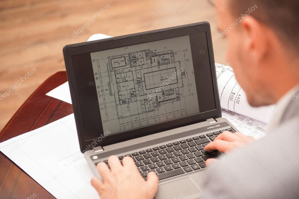 Close-up portrait of laptop with blueprints