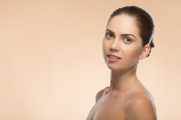 Young woman with beautiful healthy face - isolated on beige back