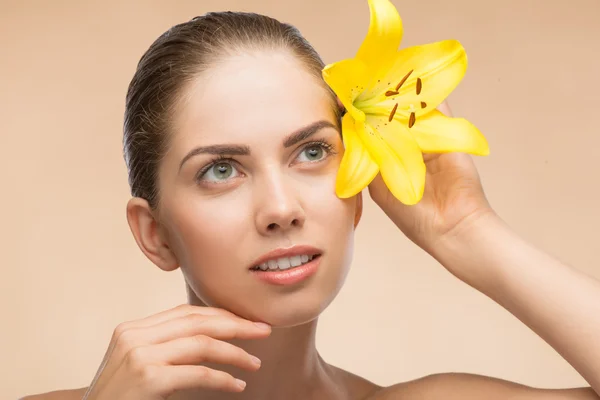 Beautiful girl in spa with flower near her face — Stock Photo, Image