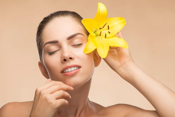 Beautiful girl in spa with flower near her face — Stock Photo, Image