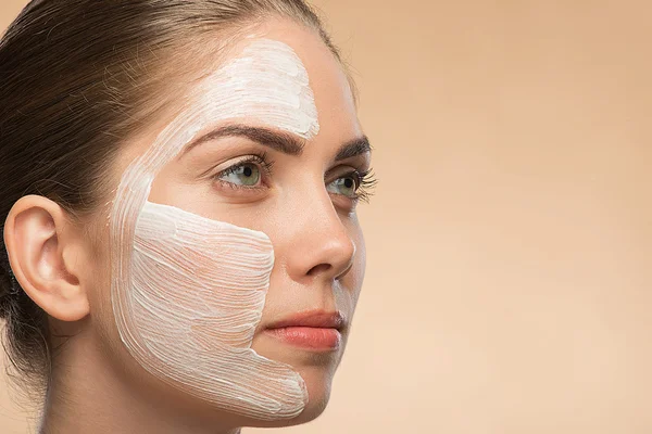 Beautiful girl in spa with cosmetic cream on her face — Stock Photo, Image