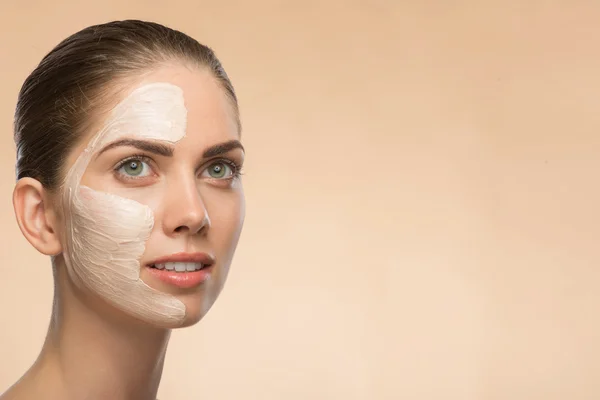 Beautiful girl in spa with cosmetic cream on her face — Stock Photo, Image