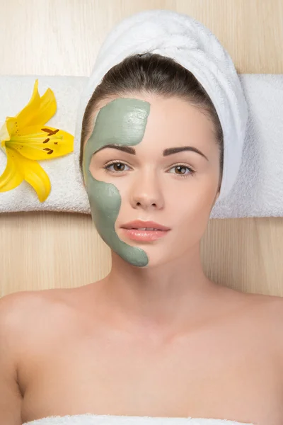 Beautiful girl with a towel on her head applying facial clay mas — Stock Photo, Image
