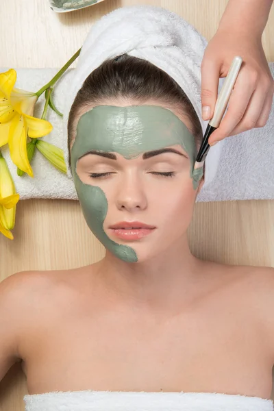 Beautiful girl with a towel on her head applying facial clay mas — Stock Photo, Image