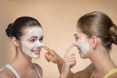 Girls applying facial cream mask clipart
