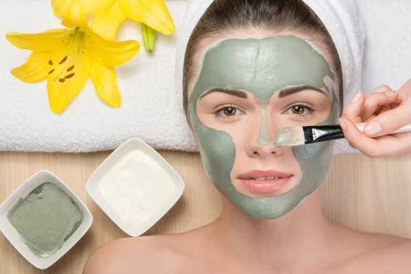 Chica aplicando mascarilla facial crema —  Fotos de Stock