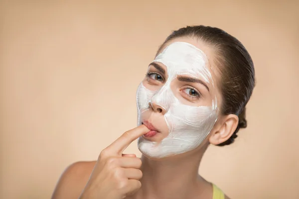 Chica aplicando mascarilla facial crema — Foto de Stock