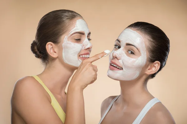 Meninas aplicando máscara creme facial — Fotografia de Stock