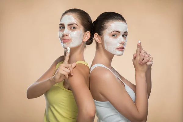 Chicas aplicando mascarilla facial crema —  Fotos de Stock
