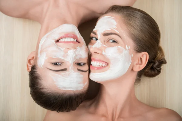 Meninas aplicando máscara creme facial — Fotografia de Stock