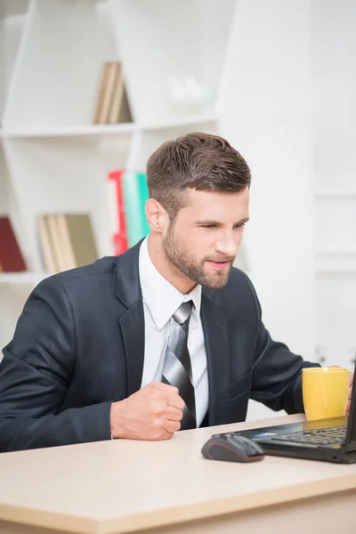 Arg affärsman med kaffe-paus och tittar på laptop — Stockfoto