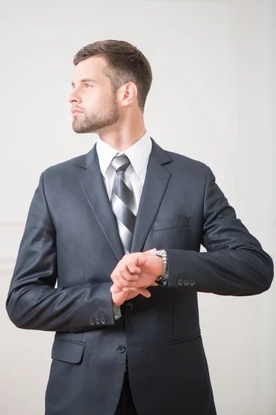 Podnikatel stojící a dojemné hodiny na ruce — Stock fotografie