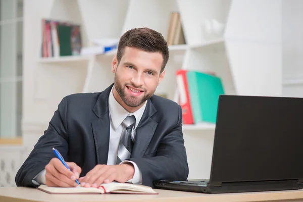 Empresario escribiendo algunas notas en cuaderno — Foto de Stock